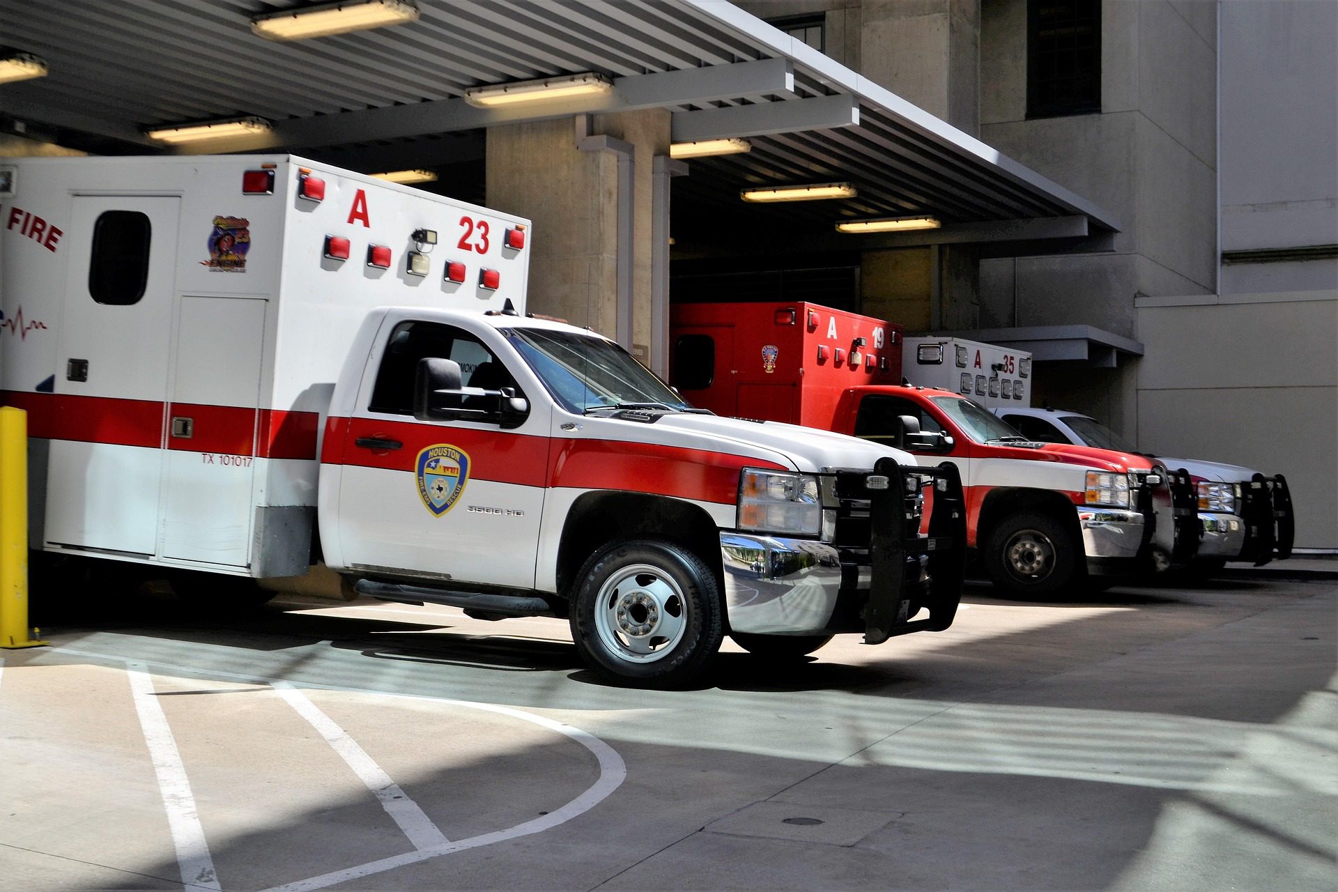 Image is an ambulance bay of an emergency department with three ambulances parked in it.