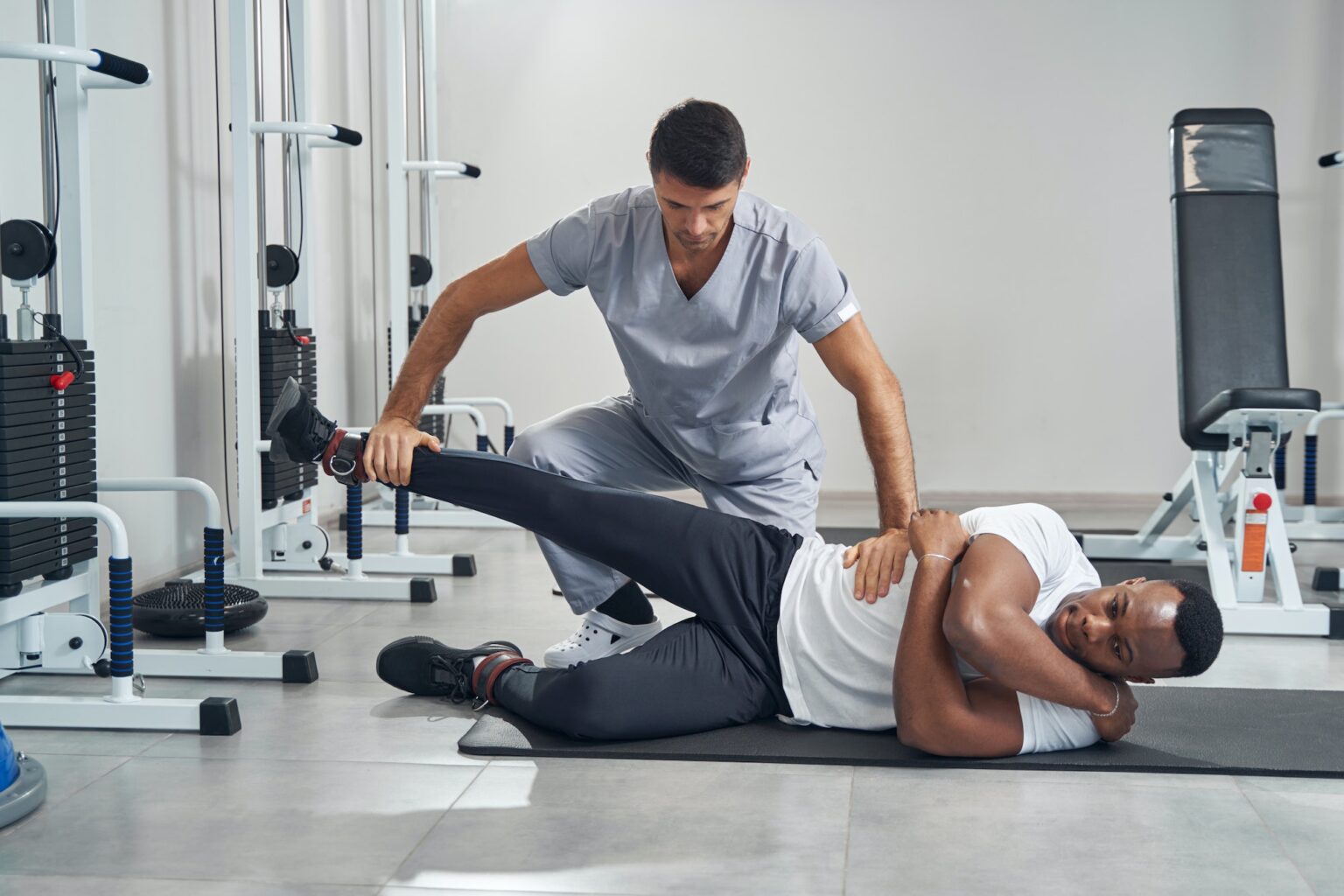 Physiatrist assessing lower body strength of man